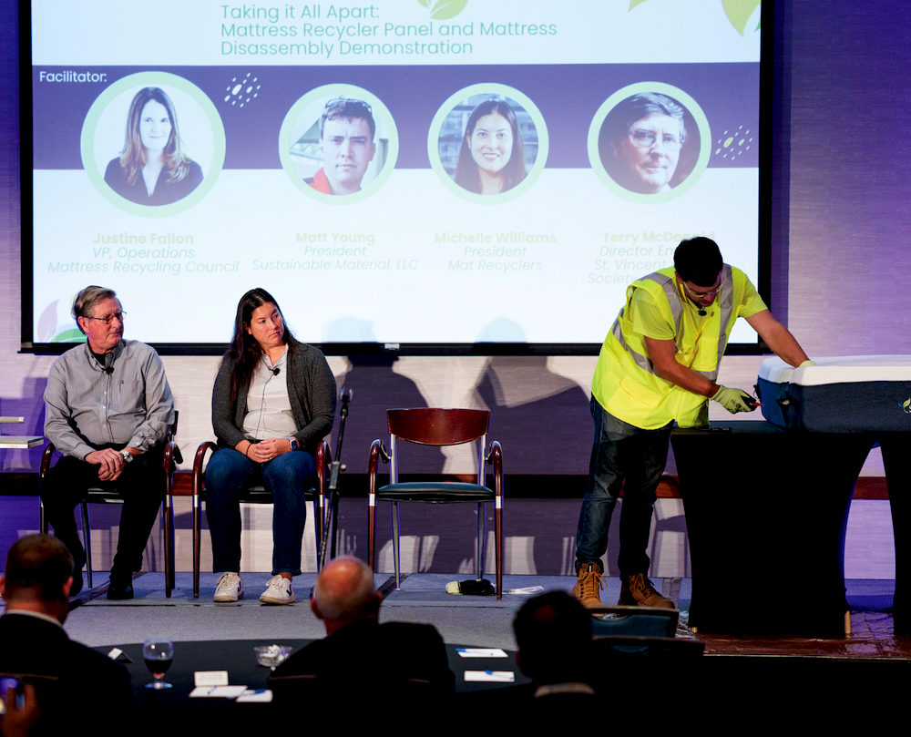 Matt Young, president of Sustainable Material LLC, takes a knife to a mattress onstage to show what recyclers encounter when deconstructing a mattress for recycling while panelists
and fellow recyclers Terry McDonald and Michelle Williams, look on. 