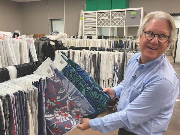 Total look, one stop. In the design studio, Taber Wood displays some recent designs. His right hand holds a fabric for Kingsdown inspired by a 1960s bikini.