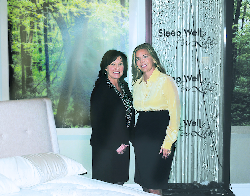 Stranix poses with Lorie Silva, a former mattress buyer at Jordan’s Furniture. 